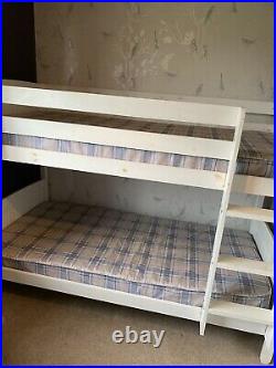 White wooden bunk beds with mattresses